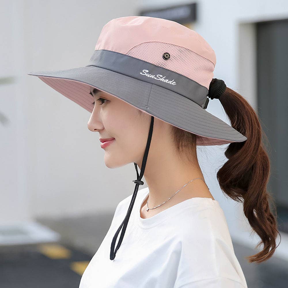 Woman wearing a pink and gray sun hat with a blurred background