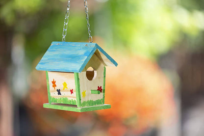 Colorful birdhouse hanging against a blurred natural background