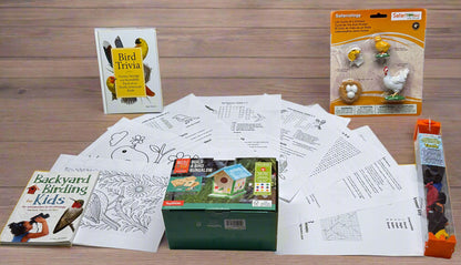 Educational materials and supplies for bird watching on a table with a brick wall background