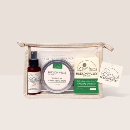Hudson Valley skincare products including a bottle, jar, and bar soap in a canvas bag on a light background.