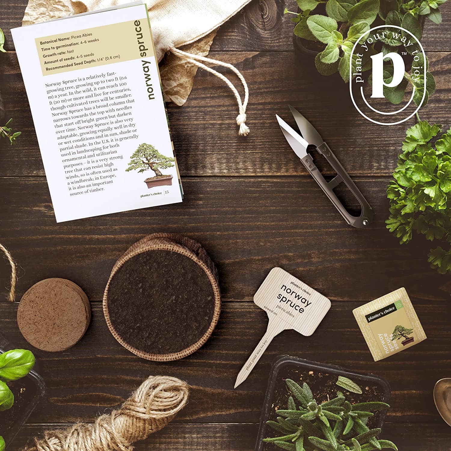 Gardening supplies including seed packets, soil, and tools on a wooden surface with a plant and branded paper.