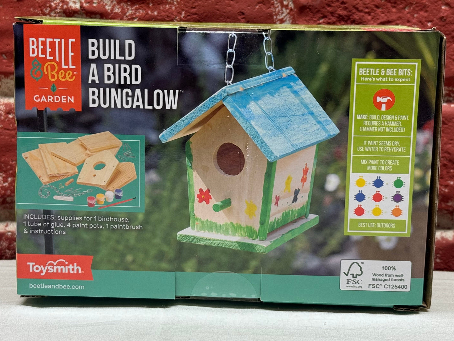 Birdhouse building kit packaging with a brick wall background