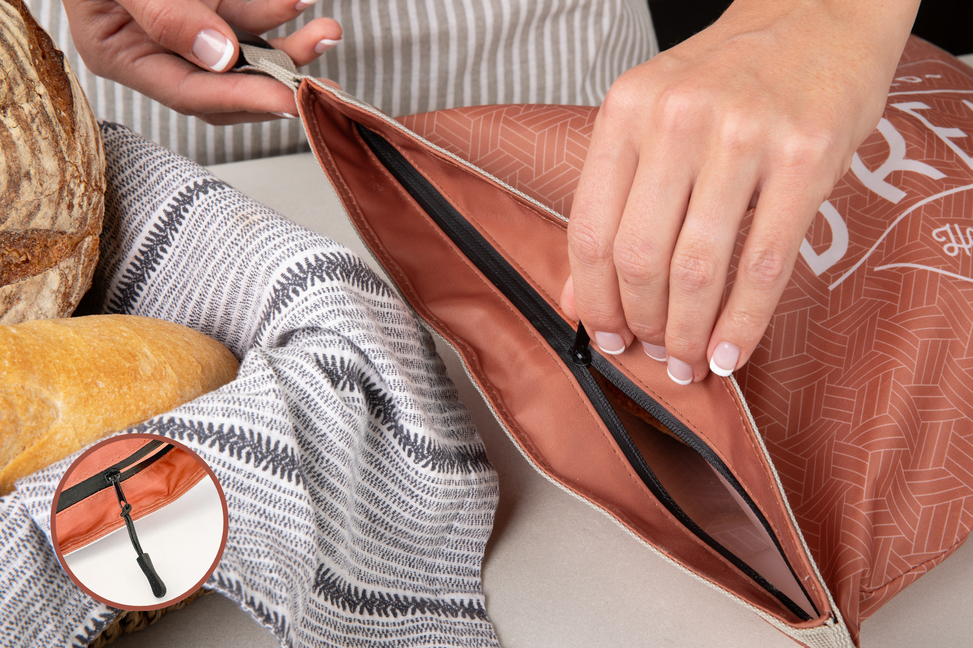 Person opening a brown leather bag with bread on a table