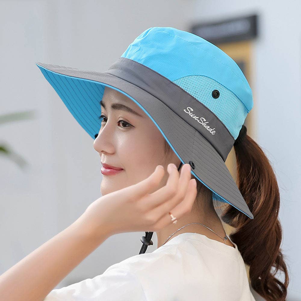 Woman wearing a blue and gray sun hat with 'Sun Shade' branding.