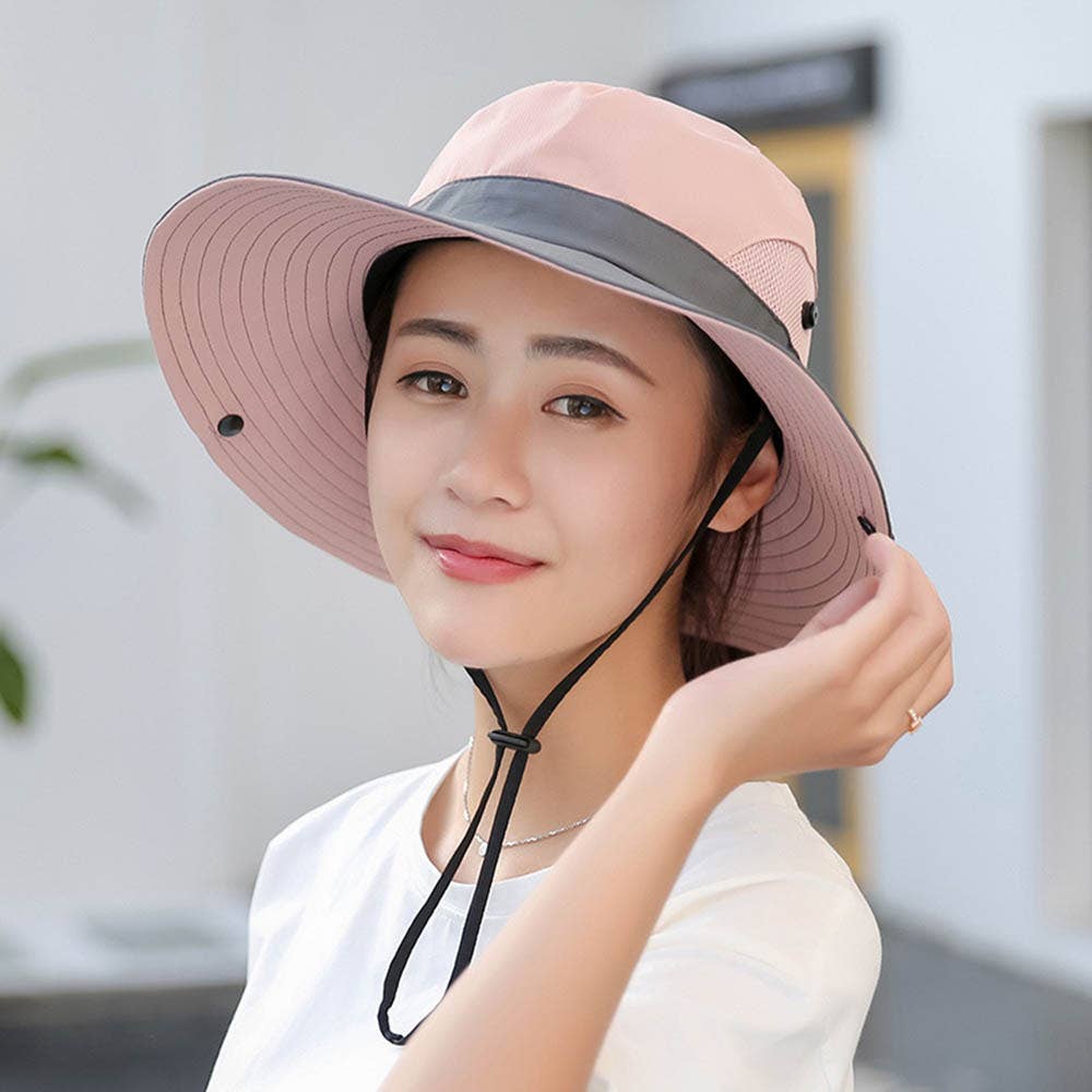 Woman wearing a pink sun hat with a gray band indoors