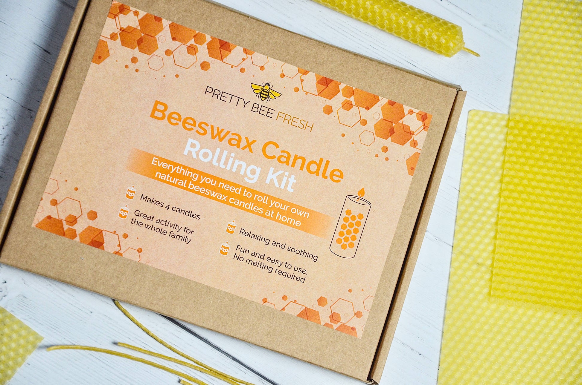 Beeswax candle rolling kit packaging with orange and brown design on a white surface.