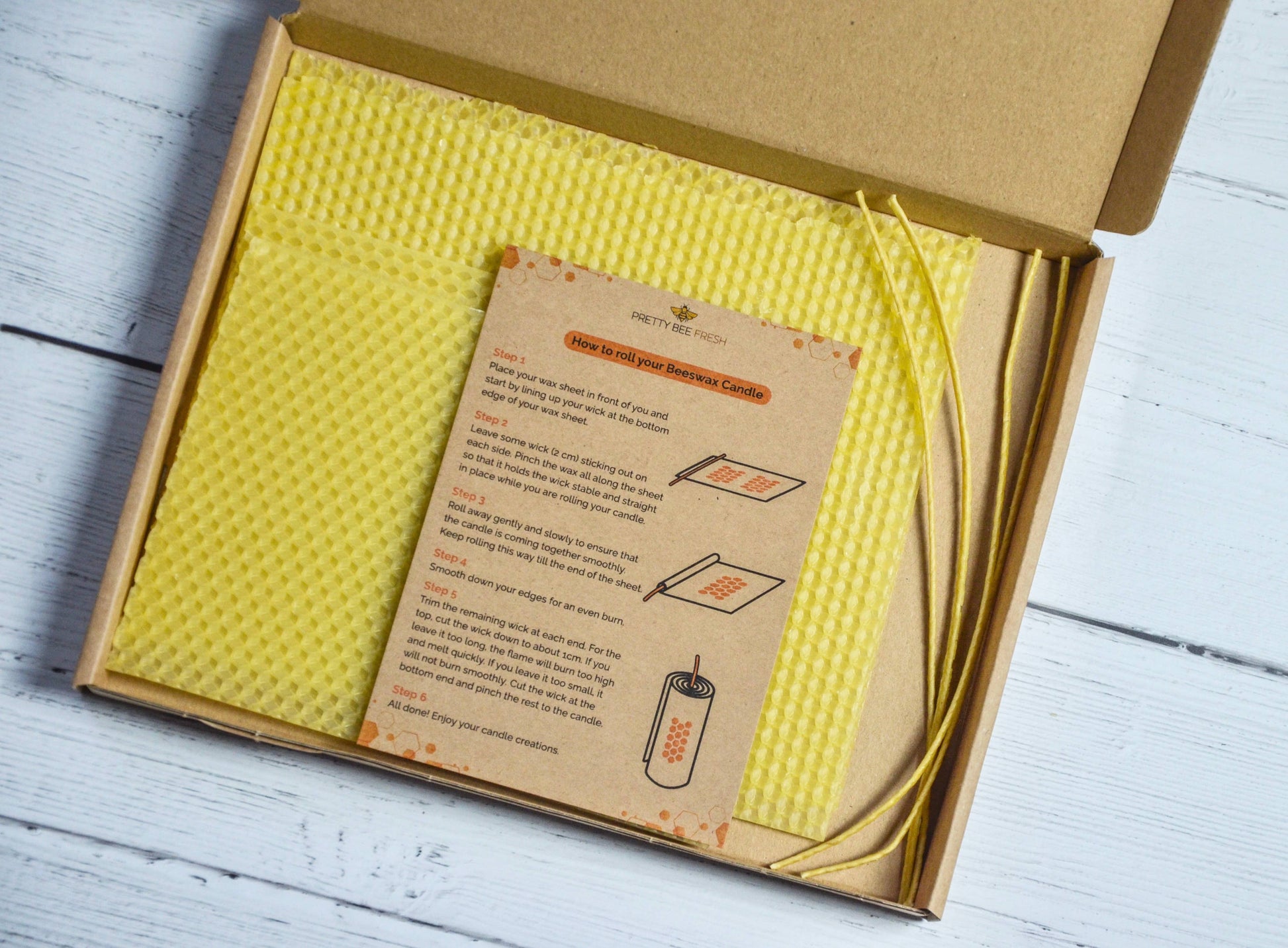 Open cardboard box with yellow honeycomb and a paper label on a wooden surface